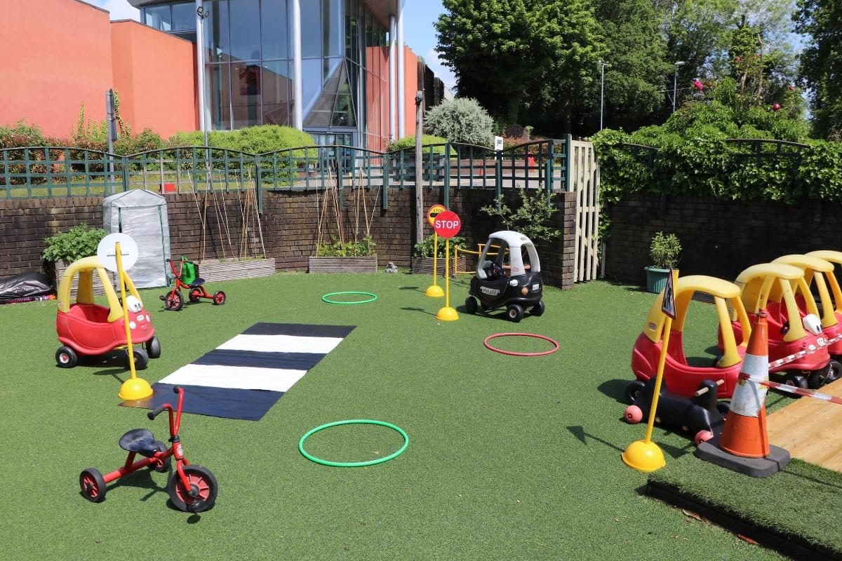 Outdoor play area with ride-on toys at Flackwell Heath nursery
