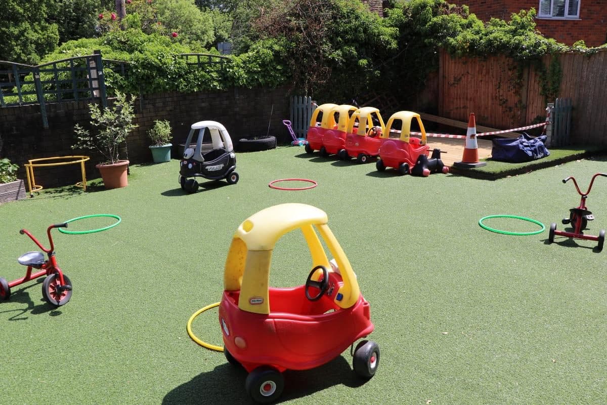 Ride-on cars and tricycles in the Flackwell Heath nursery garden