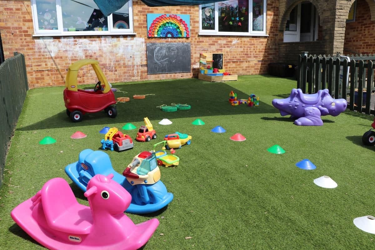 Hazlemere nursery garden with ride-on toys and artificial grass